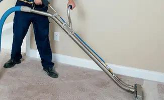Professional operating a liquid removal machine on a carpeted floor in Rochester, NY